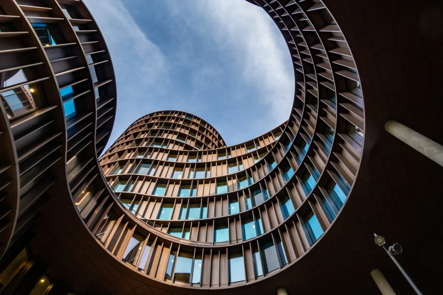 Upward view of curvilinear building architecture.