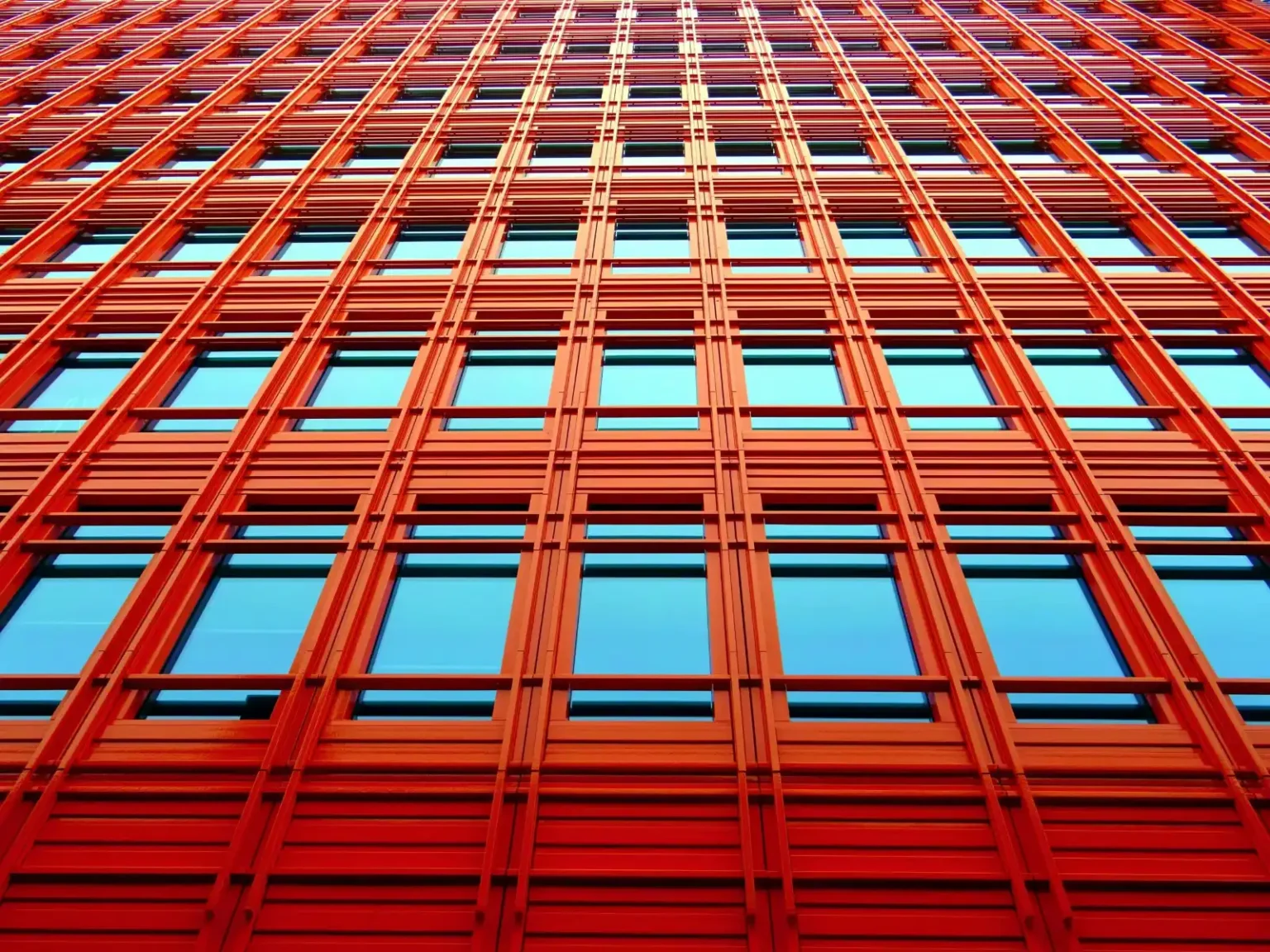 View looking up at a tall red building with windows